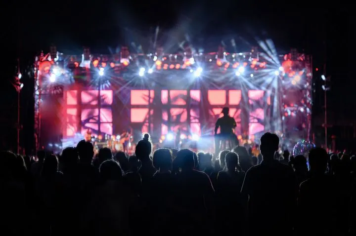 A night stage at Electric Picnic lit up with bright coloured lights and a large crowd